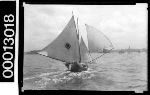 Yacht with a Union Jack emblem under sail near Fort Denison, Sydney Harbour