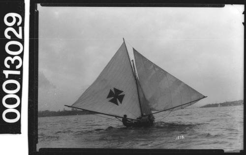 Yacht with a Maltese Cross emblem on the mainsail, Sydney Harbour