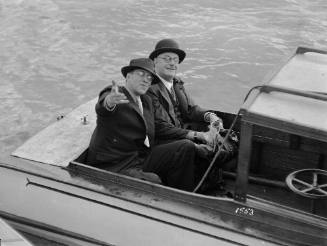 Two men seated in a motor launch on Sydney Harbour