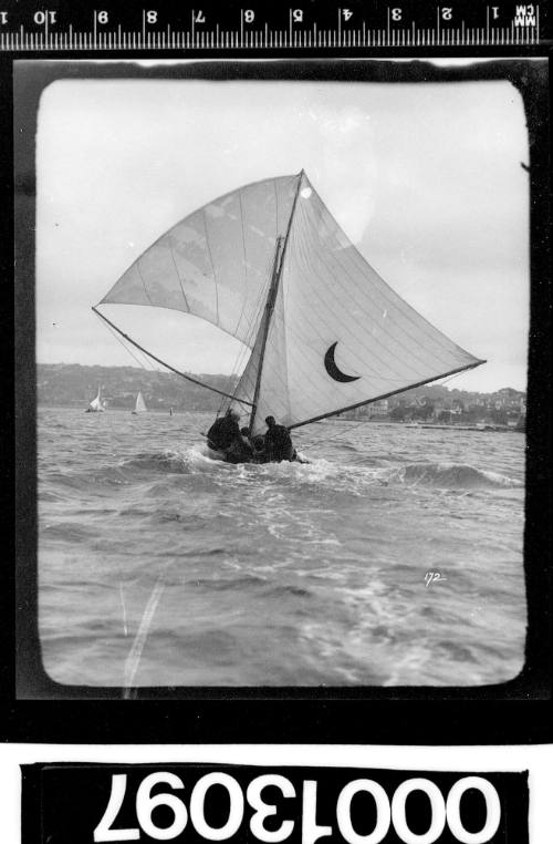 Yacht with a crescent moon emblem on the mainsail, Sydney Harbour