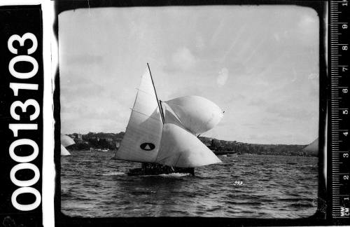 Yacht displaying an emblem of a light triangle within a dark oval on the mainsail, Sydney Harbour