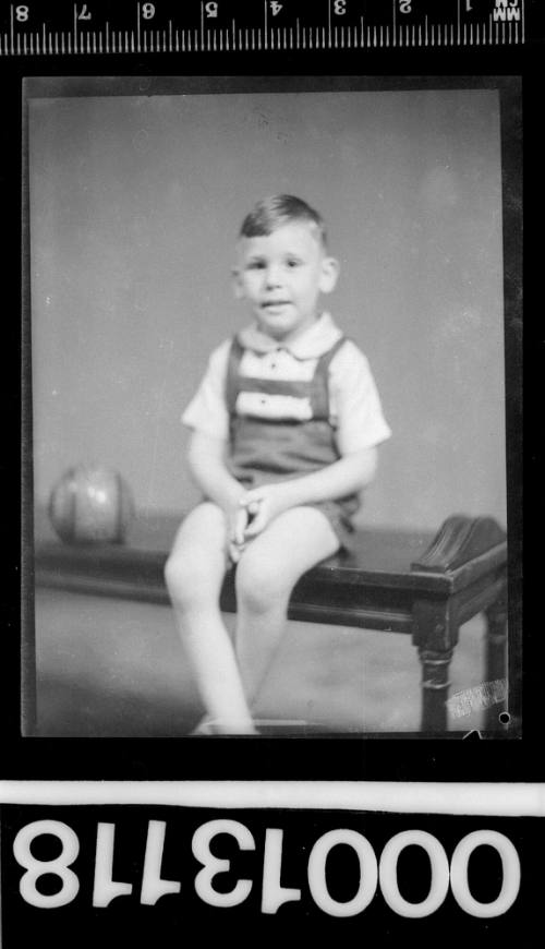 Portrait of a young boy sitting on a wooden table