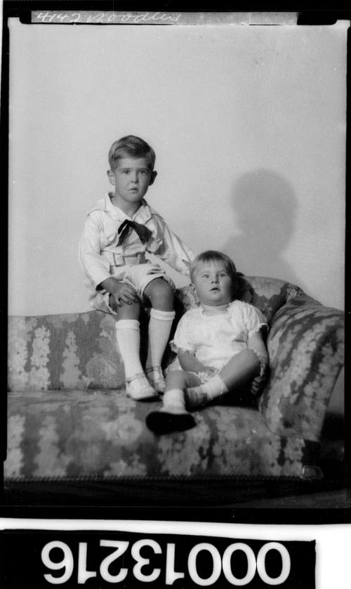 Portrait of two children sitting on a couch