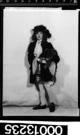 Portrait of a performer in costume holding a small dog