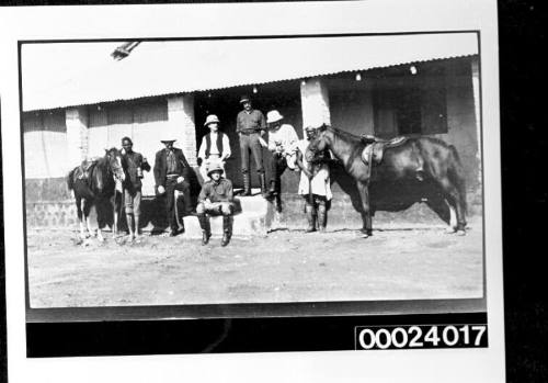 Group of white men and Africans outside a building