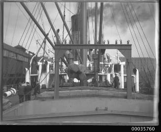 Deck view of SS ALLER showing bales of wool been lowered into ship's hold.