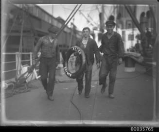 SS ALLER, three crew on deck on carrying a lifebuoy