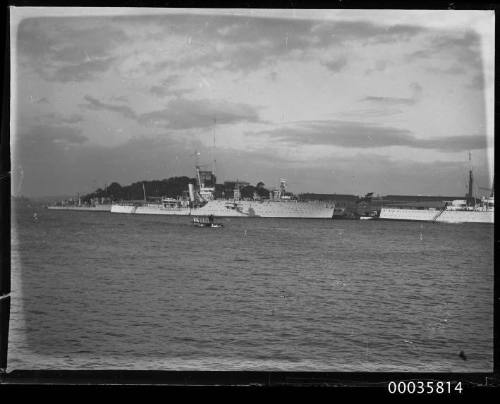 View of three warships and a seaplane in harbour