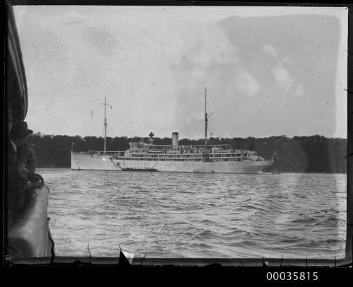 View of unidentified vessel with cross sign in harbour.