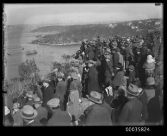 View of a crowd positioned on a headland overlooking Sydney Harbour