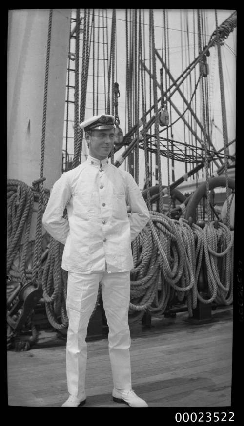 Portrait of a merchant marine officer standing in front of a ship's mast and rigging