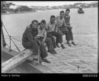 Crew members sitting on mast of HELEN B. STERLING