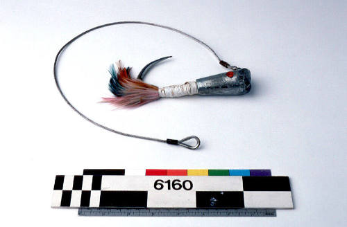 TUNA FISHING LURE, METAL HOOK WITH COLOURED FEATHERS (BLUE, ORANGE AND  PINK) TAPED TO SHAFT WITH WHITE PLASTIC TAPE, TWO ROUND RED INSERTS TO  IMITATE EYES, METAL CABLE ATTACHED TO HOOK –