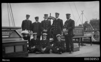 MERSEY Group photo ship's officers near wheel.