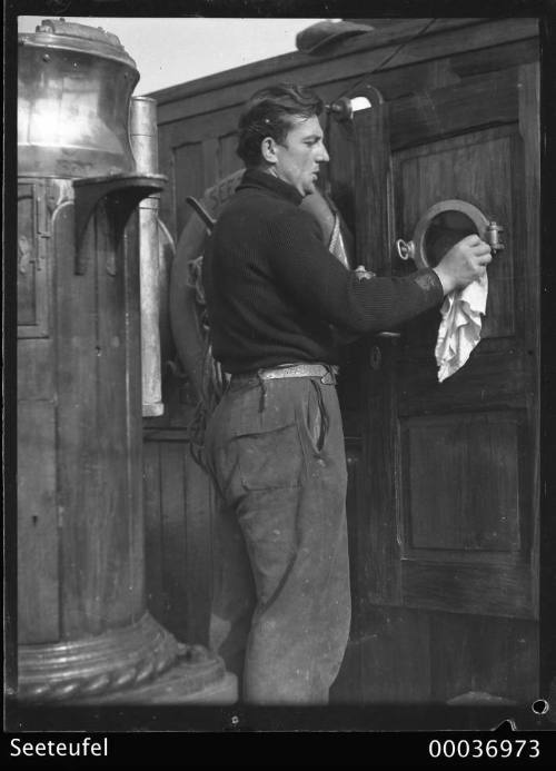 Crew member cleaning brass on board SEETEUFEL