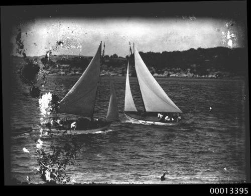 Two gaff -rigged yachts cross tack on main harbour