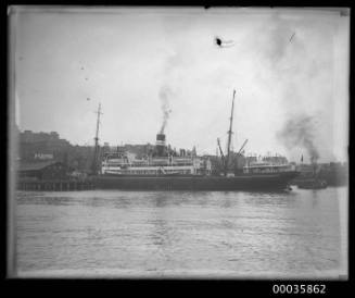 View of unknown passenger vessel departing from wharf in harbour.