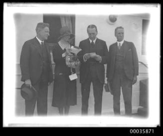 Portrait of four dignatories on deck of unidentified ship.