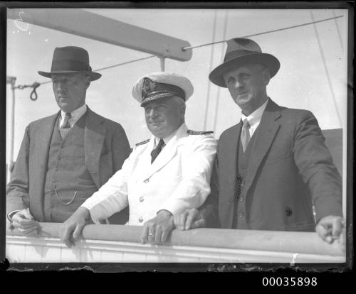 Captain and two passengers on deck of SS RUNIC possibly at Millers Point, Sydney