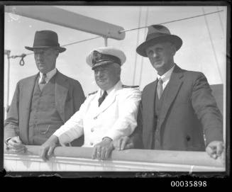 Captain and two passengers on deck of SS RUNIC possibly at Millers Point, Sydney