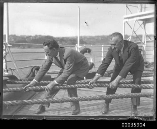 Two men pulling on ropes on deck of SS RUNIC possibly at Millers Point, Sydney