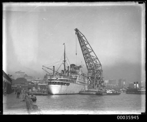 Floating crane unloading a fighter plane from the MARIPOSA during WWII