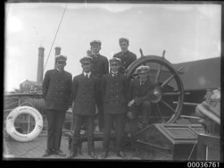 MOUNT STEWART - ship officers or cadets posing beside the ship's wheel