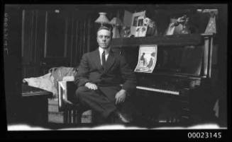 Ray Milton Sterling seated at a player piano in the saloon of E R STERLING
