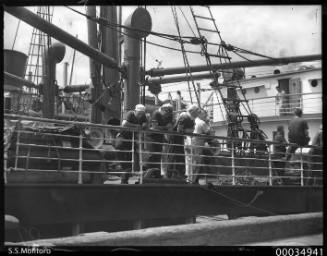 View of SS MONTORO showing six crewmen leaning on the ship's rail