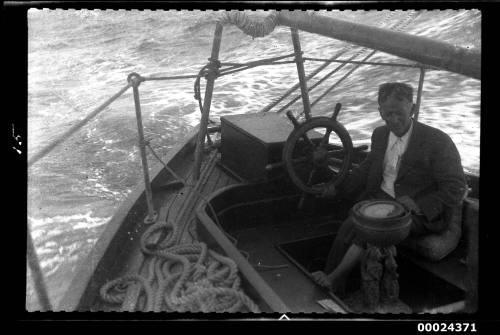 Harold Nossiter Snr watching the compass while holding the yacht's wheel