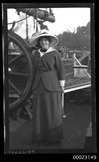 Woman standing next to the ship's wheel