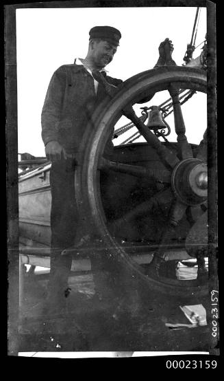 Crew member at ship's wheel of LORD WOLSELEY