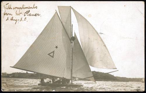 Sailing skiff with star and triangle insignia on sail