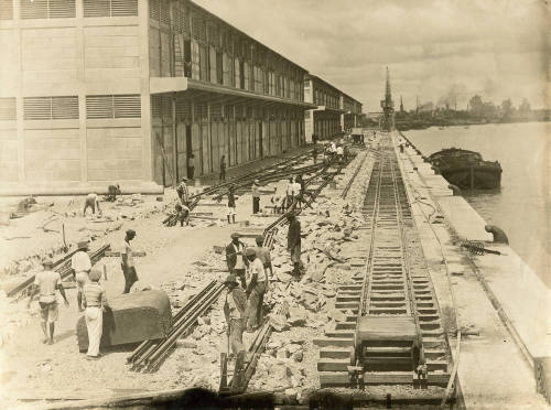 Workers laying rail tracks on a wharf in a west African port