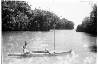 View of Oskar Speck standing in river beside his kayak SUNNSCHIEN 