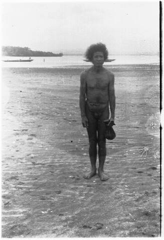 View of a man standing on a beach at low tide