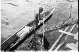 Aerial view of a man in a canoe alongside a ladder