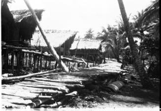 View of a row of stilted houses along a wooden walkway  