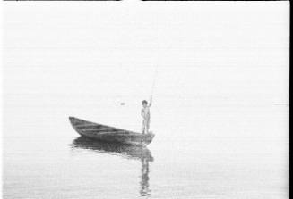 View of a child standing on the bow of canoe 