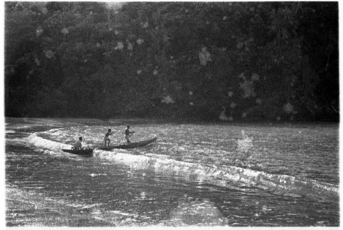 View of men in a canoe leaving the beach