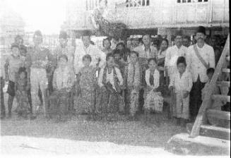 View of a group of people in front of a stilted hut