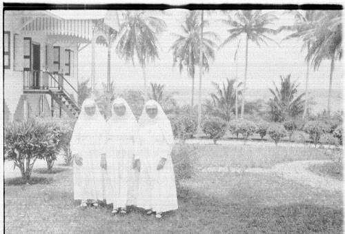 View of three nuns in front of a church 