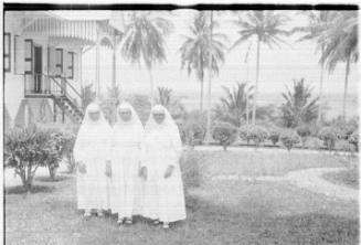 View of three nuns in front of a church 