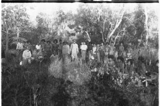 View of a group of people posing for the camera in wooded setting 