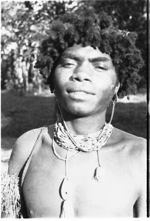 View of a young man wearing beaded jewelry 