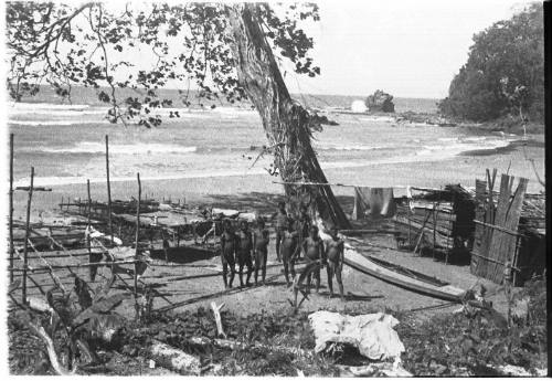 View of men standing beneath tree 