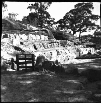 View of a gate with sandstone retaining walls 