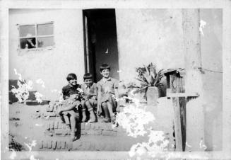 View of children seated on the steps of a house 