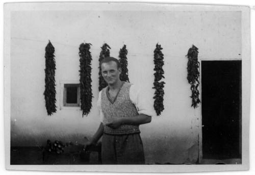 View of Oskar Speck in front of a wall with drying chilies