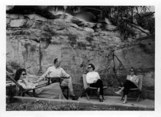 View of Oskar Speck and friends seated outdoors at Killcare